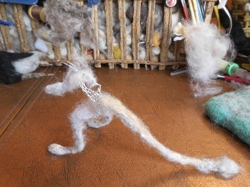 Wool wrapped around the legs and tail and loosely felted in place through the wire, with additional wool felted over it to hide the spirals. Pic #10