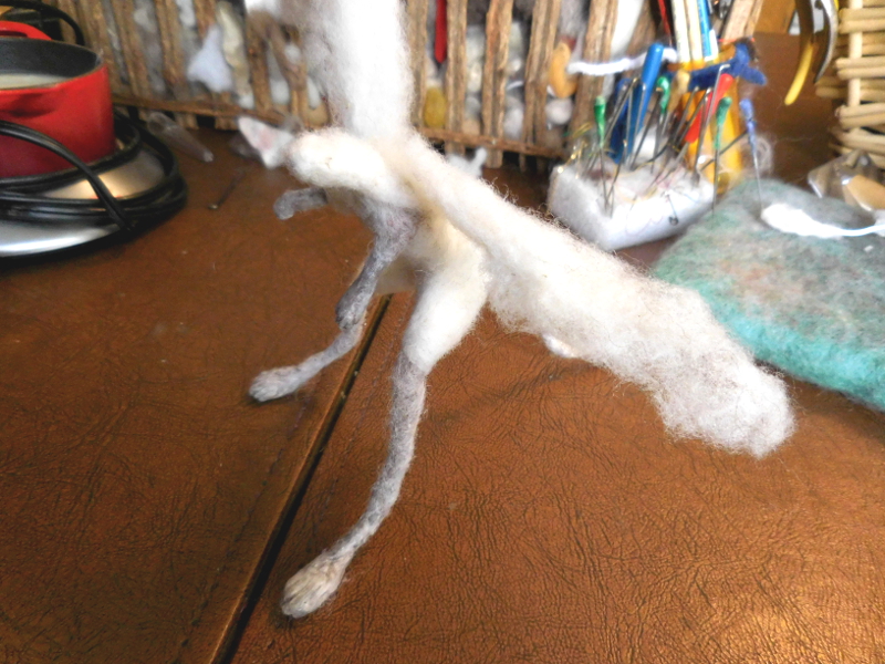 A long plume of wool will add bulk to the shoulders once it’s tightly wrapped and felted in place. (Note the new wax work on the legs: full dip on the forelegs and enough added to the hind legs to smooth them out.) Pic #14: Developing the shoulders