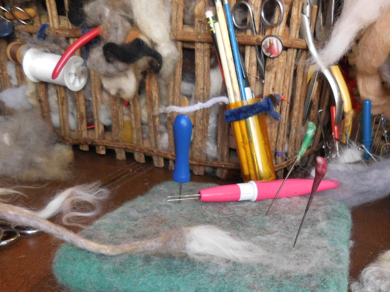 Now to the finishing touches. One thing that makes this species feasible for wearable art is the magnet-hiding tuft of hair on the end of the tail but felting over a magnet is a tricksy business. (The magnet is hard enough to damage the needle and fragile enough to chip or crack if you hit it wrong.) Instead of waxed wool, the tail magnet is in a dense envelope of needle and wet felting. Pic #39: First part of tail tuft